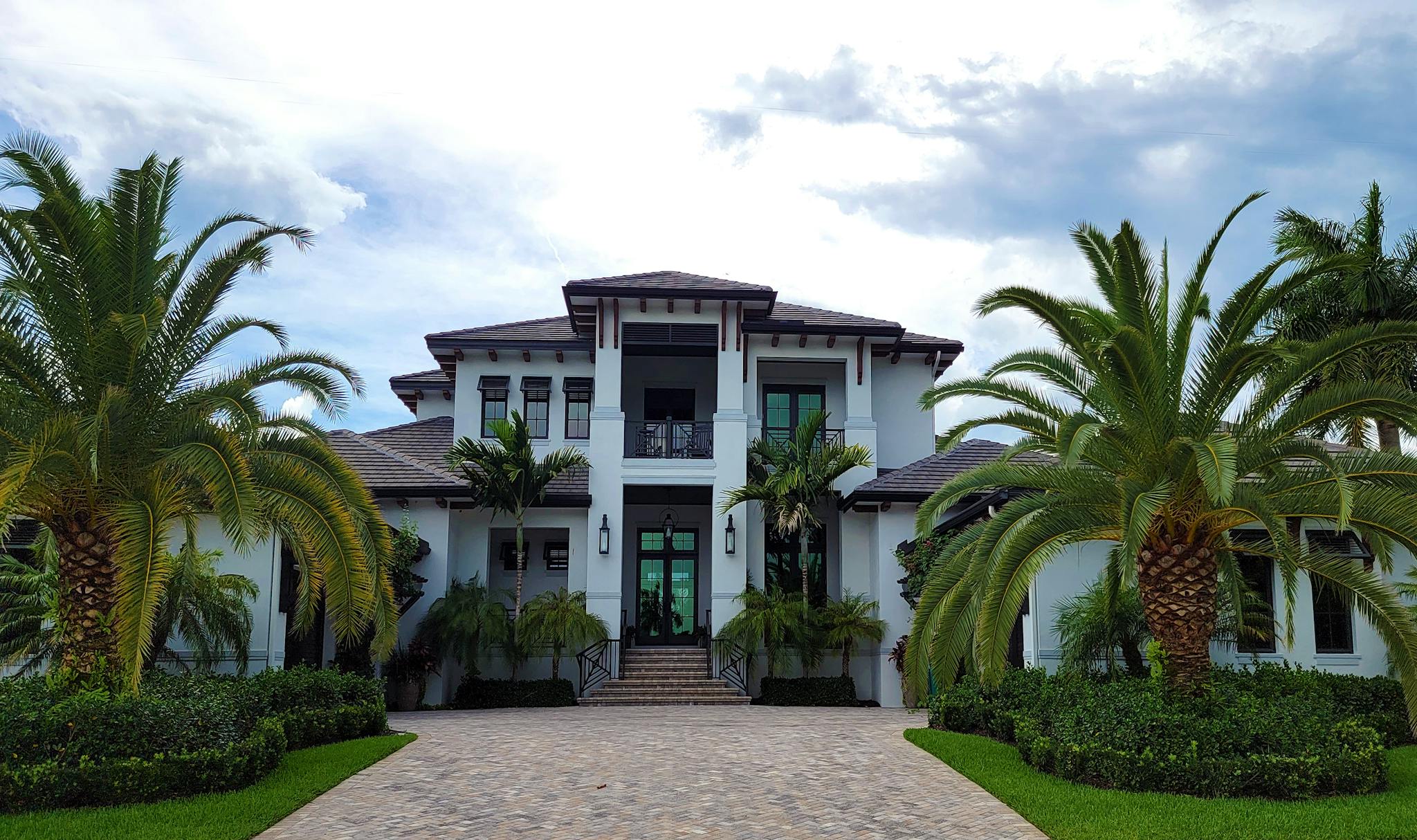 A stunning modern residential building with palm trees and clean architectural design.