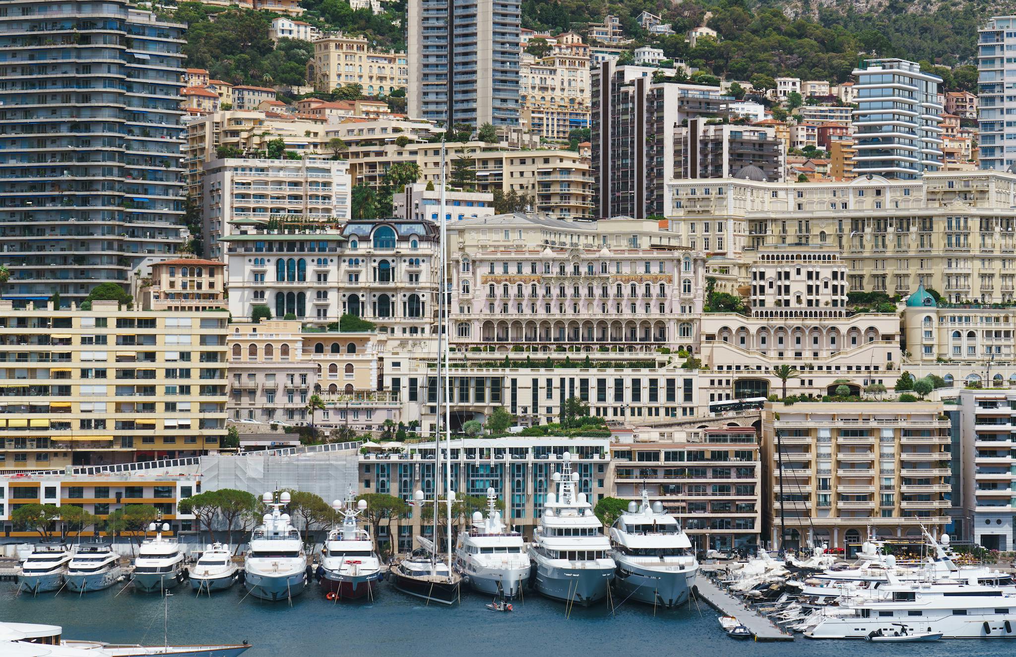 Luxurious yachts moored along Monaco's stunning marina with city skyline.
